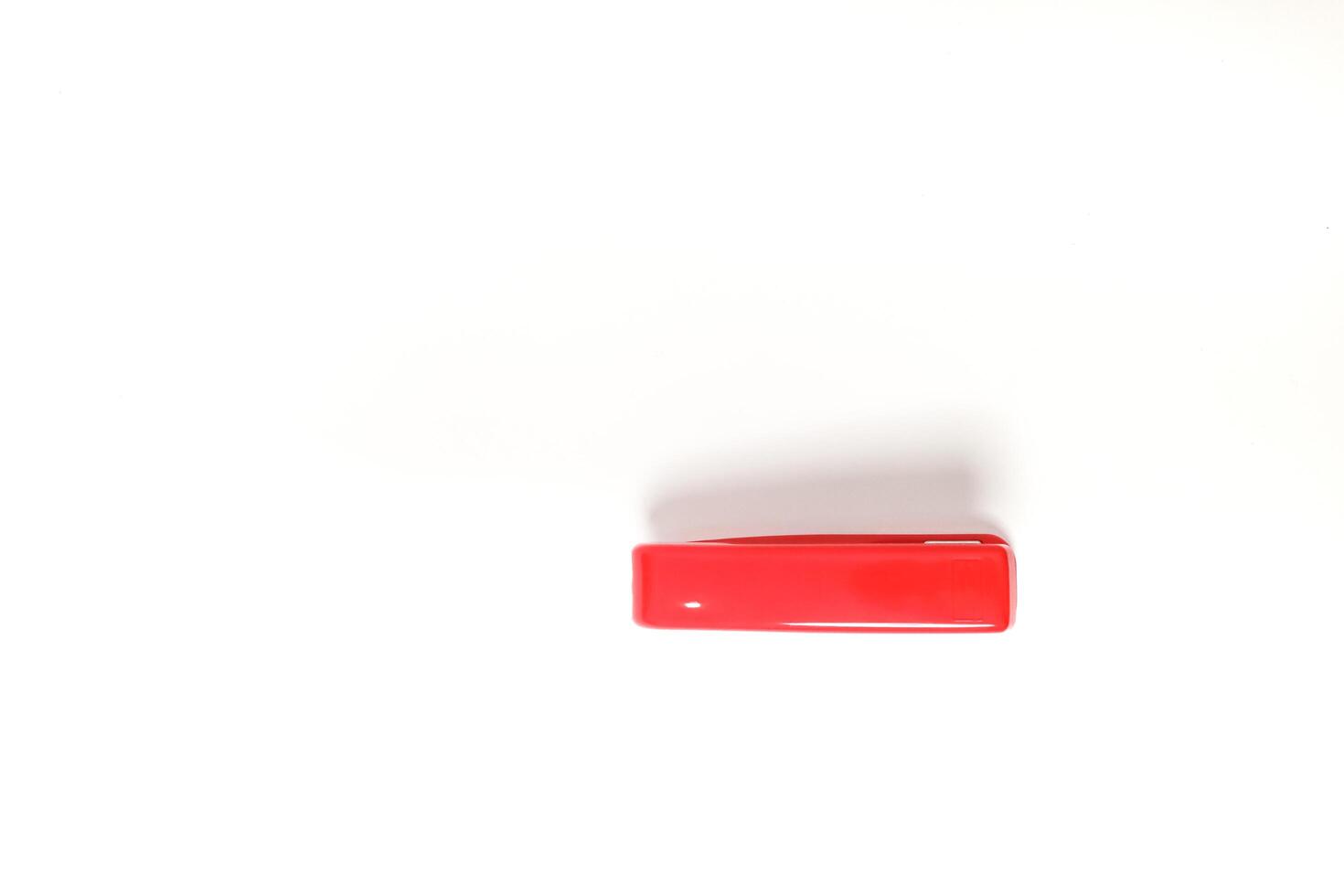 Minimalist shot showcasing a vibrant red rectangular object on a crisp white surface photo