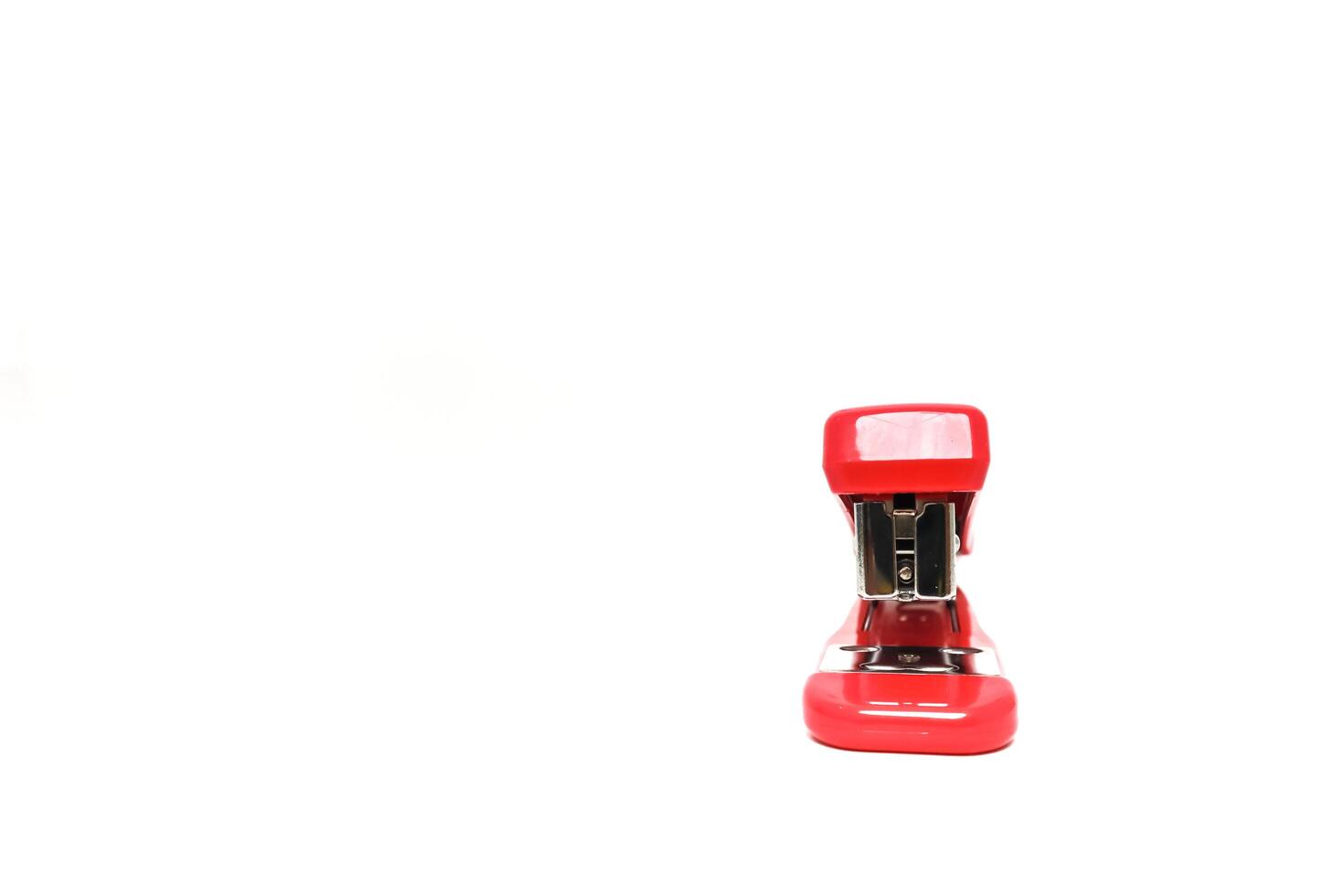 A Vibrant Red Stapler Stands Out on a Crisp White Backdrop, Perfect for Office or School Use photo