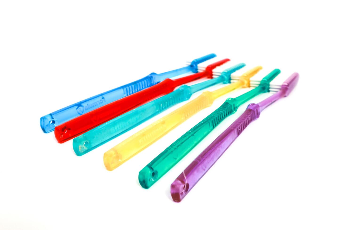 Colorful Transparent Toothbrushes Aligned on White Background, Dental Care Essentials photo