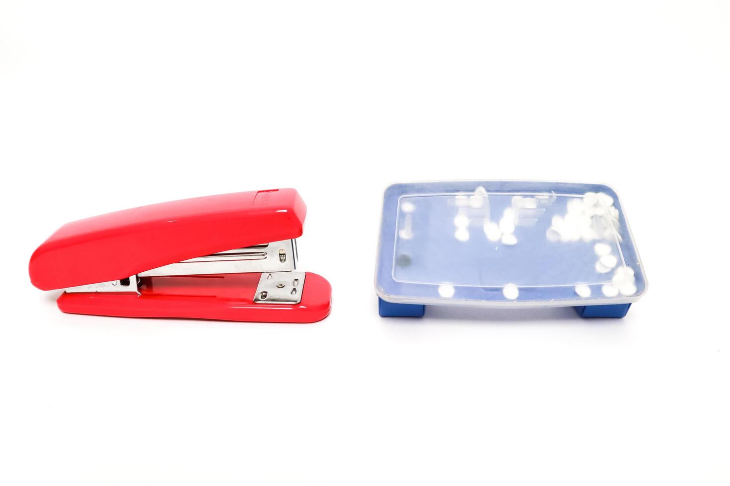 Red stapler and staple box on a white background in a studio shot for stationery needs photo