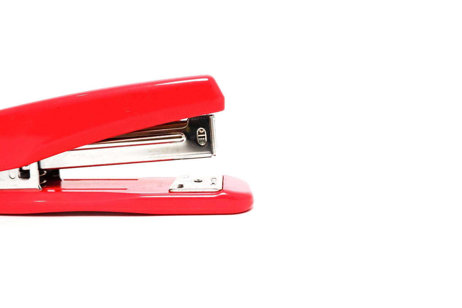 Close-up of a vibrant red stapler on a clean white surface, perfect for office supply mockups photo