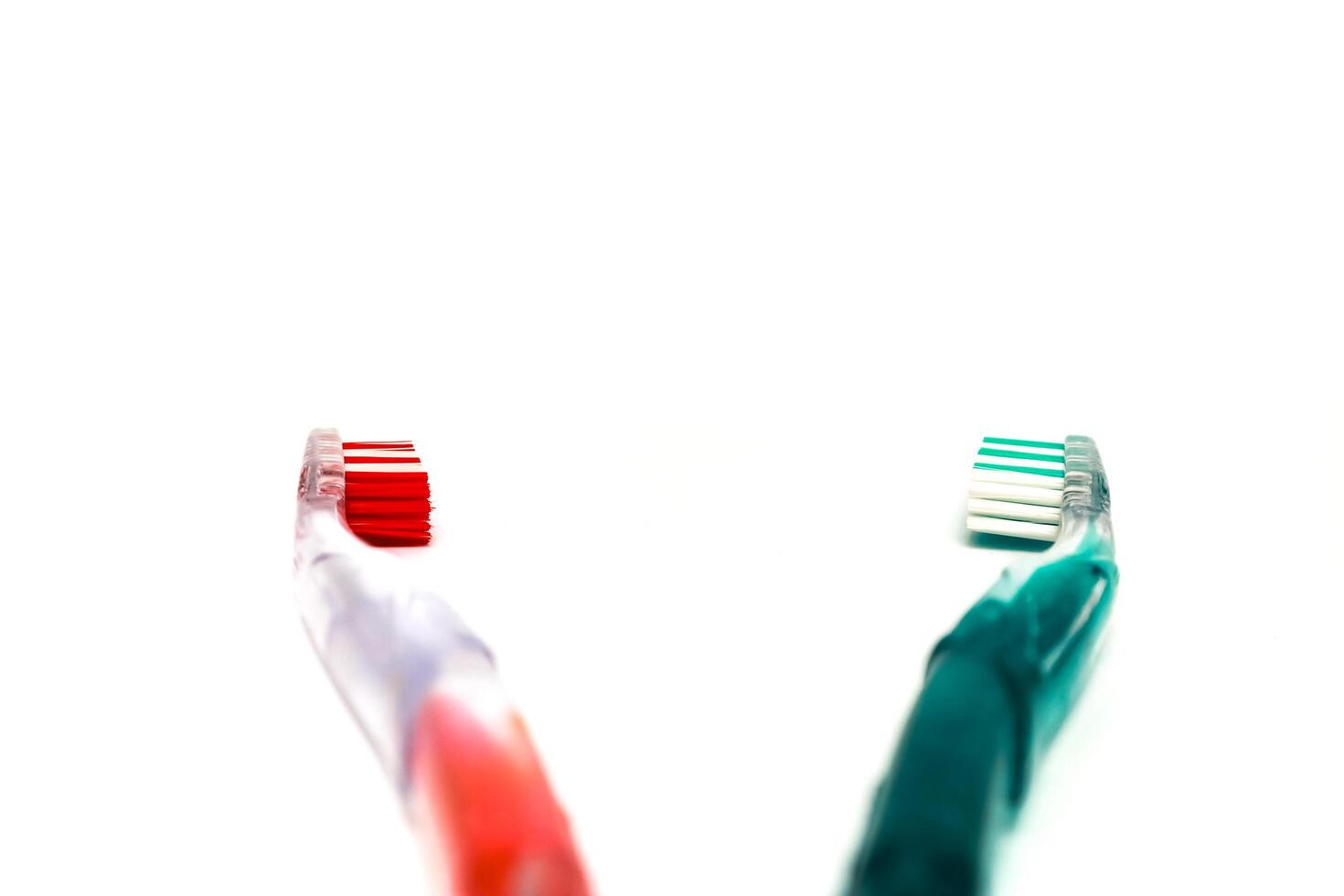 A Red and Green Toothbrush Pair on a White Background, representing dental care and hygiene, promoting oral health and wellness photo