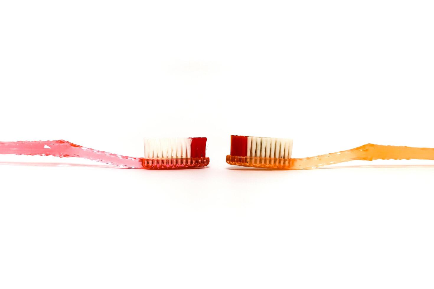 Two toothbrushes facing each other on a white background representing dental hygiene and care photo
