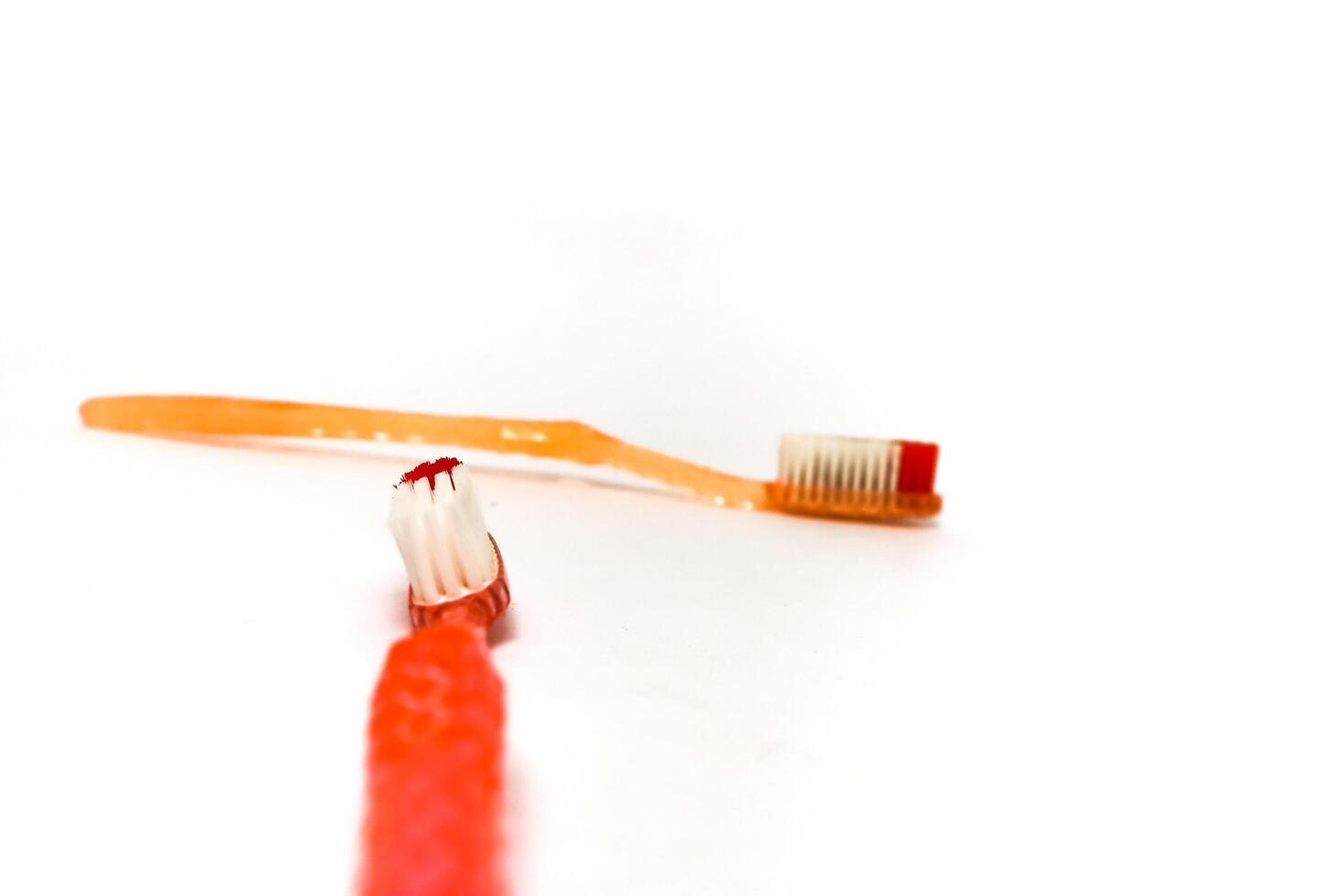 Close-up of two used toothbrushes with worn bristles on a white background, suggesting oral hygiene and dental care photo