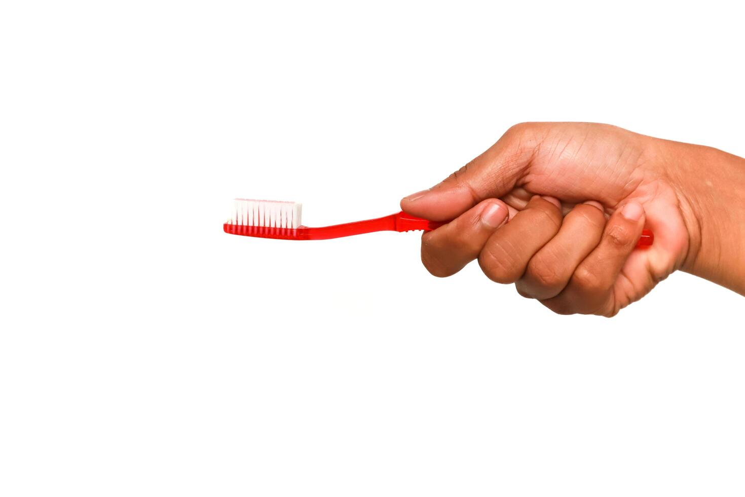 Hand holding a red toothbrush promoting proper oral hygiene and dental care photo