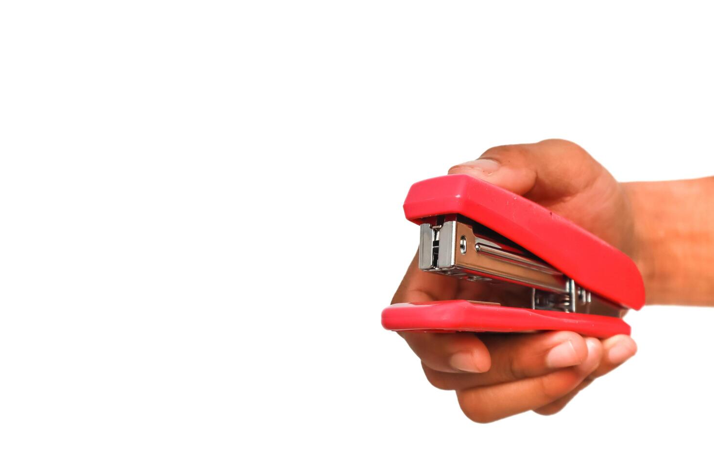 Hand holding a red stapler on a white background perfect for office supply concepts photo