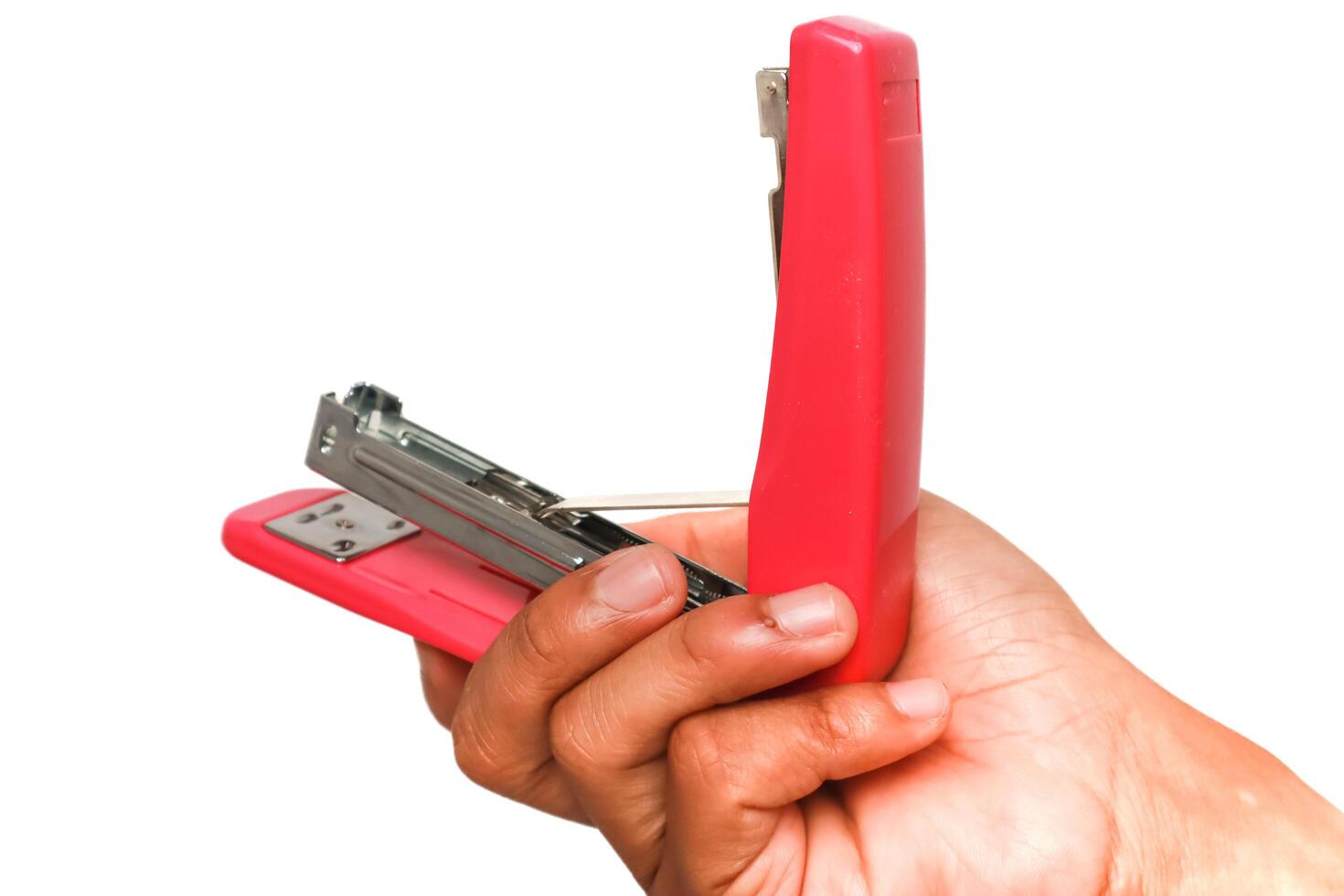A hand holding a pink stapler against a clean white background, office equipment photo