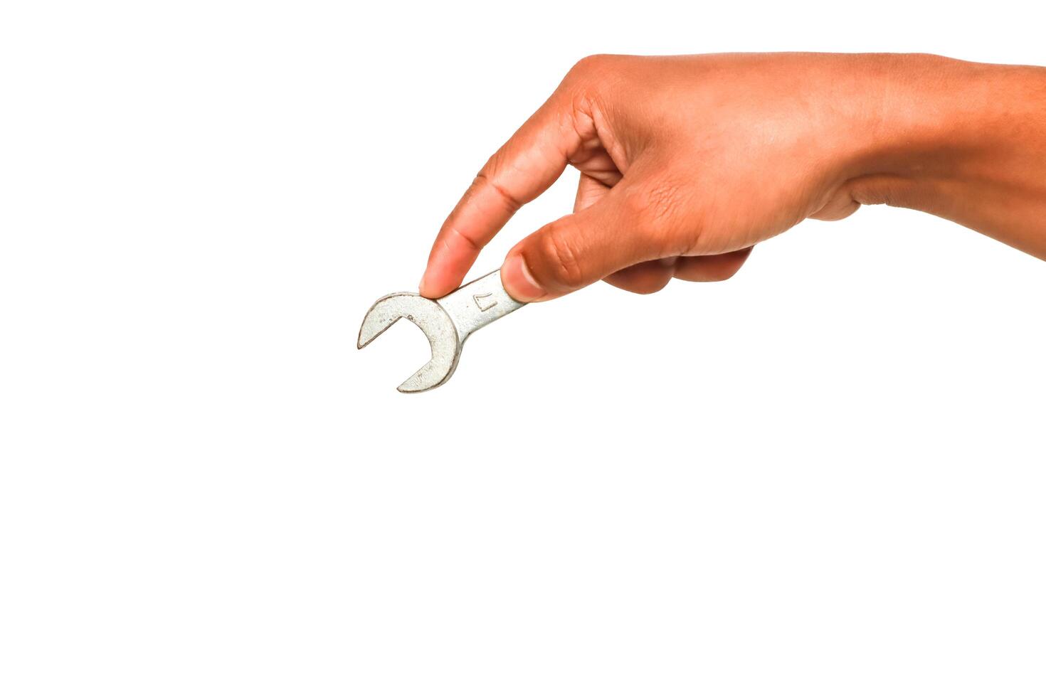 Hand holding an open-end wrench on a white background for mechanical repair concepts photo