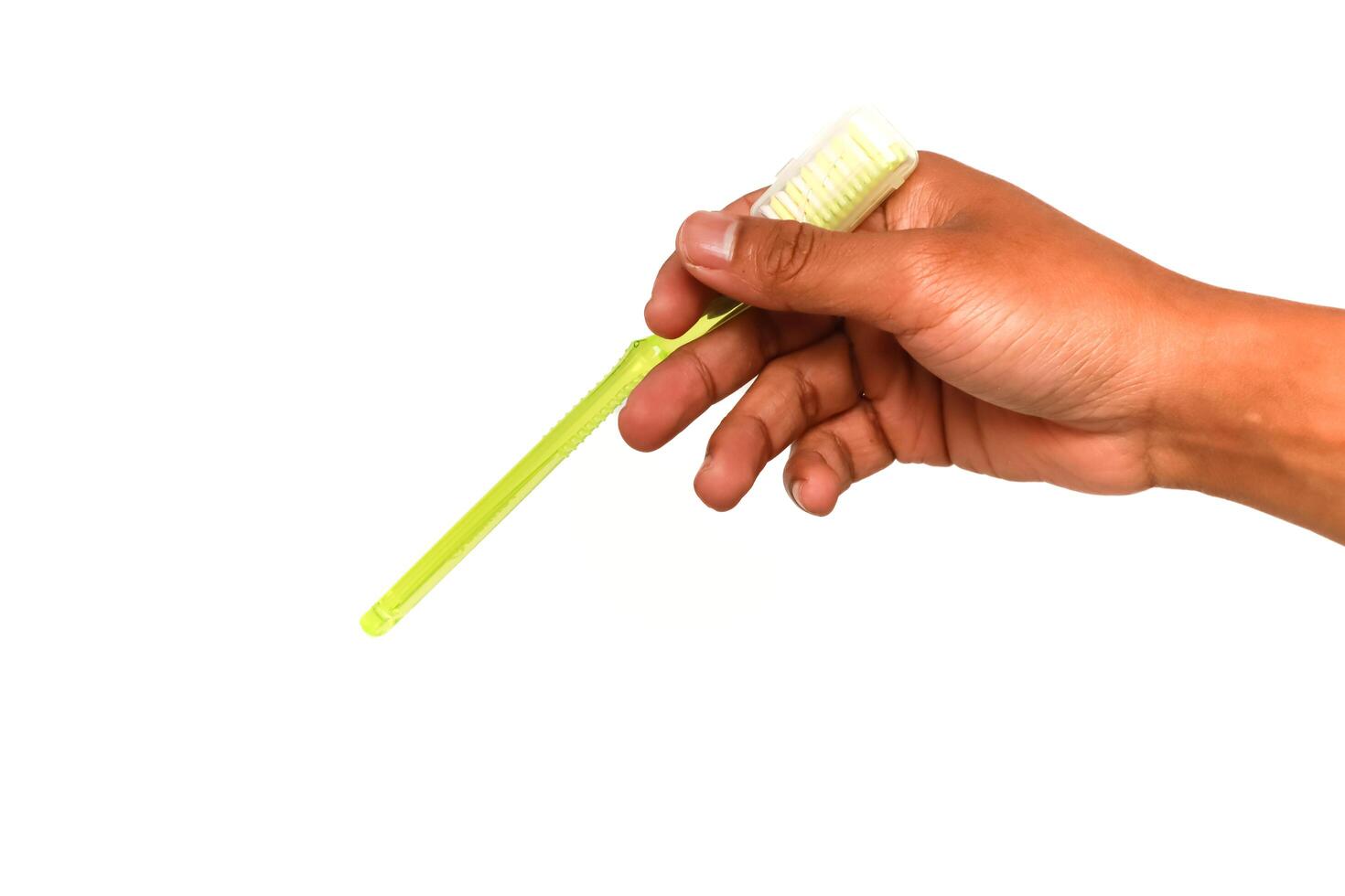 Hand Holding a Yellow Corn Cob Holder Tool Isolated on White Background, ready to eat grilled corn on the cob photo