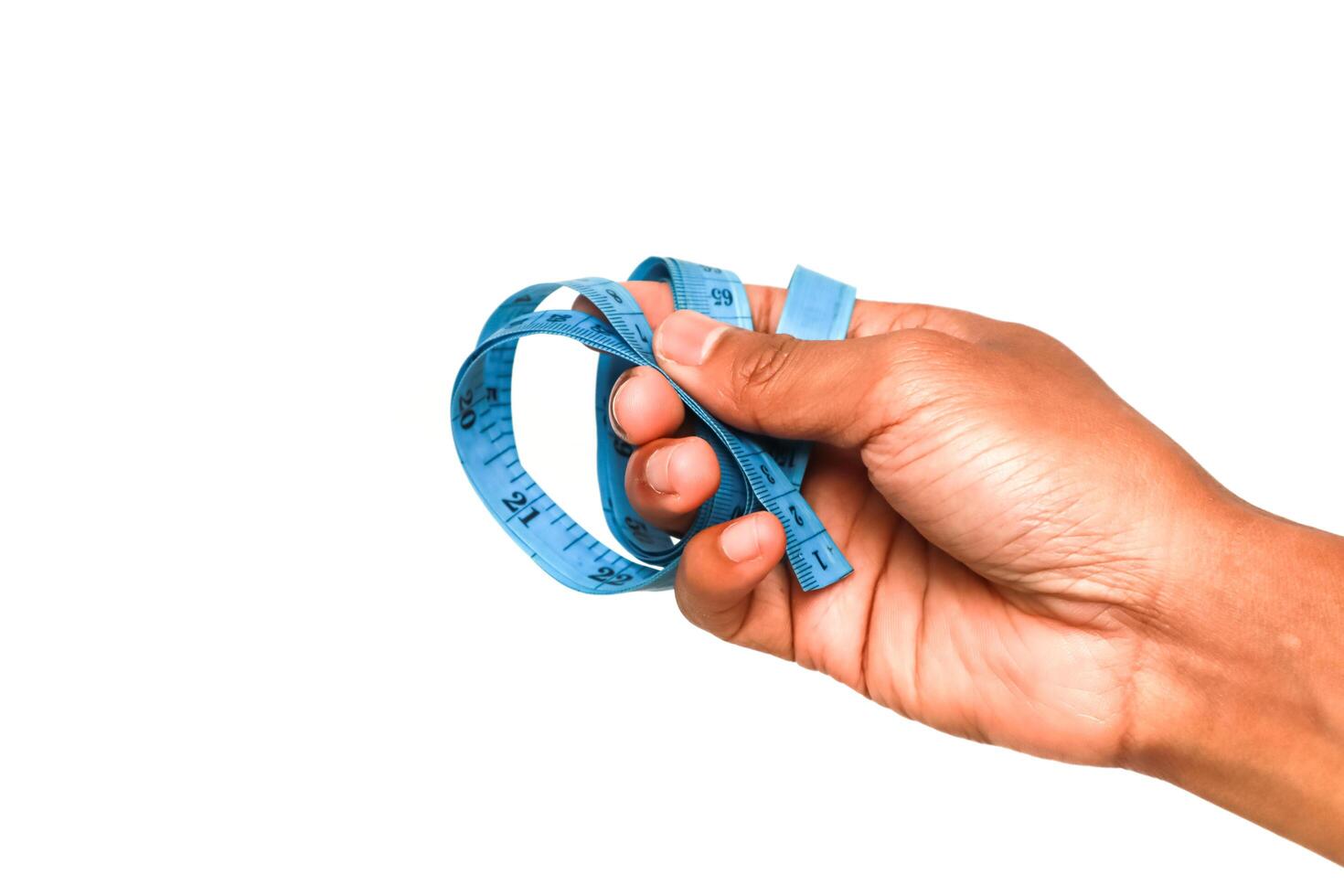 Hand gripping a blue measuring tape against a stark white background highlighting precision photo