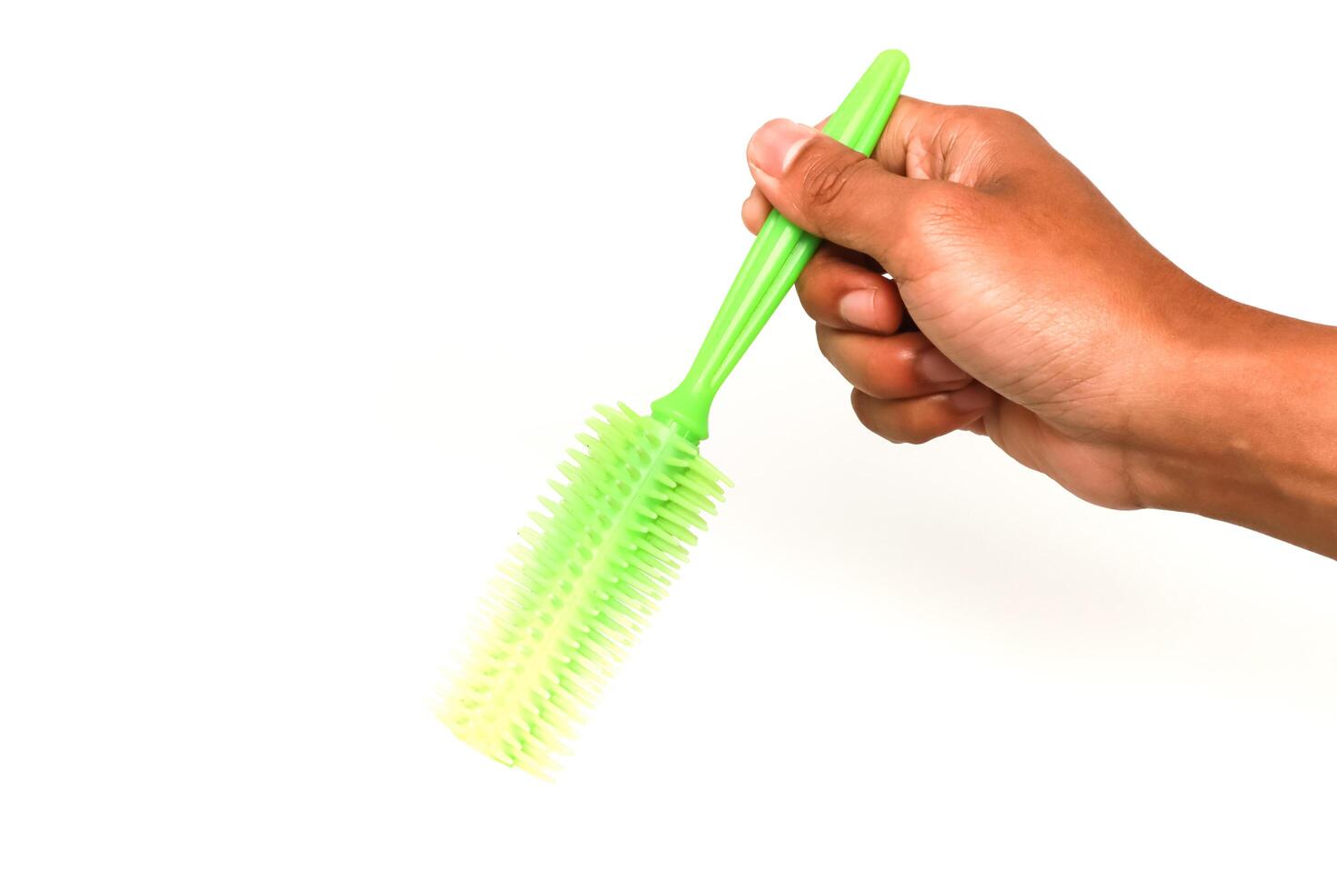 Hand holding a green bottle brush on a white background, a cleaning tool for home use, isolated shot for commercial purpose photo