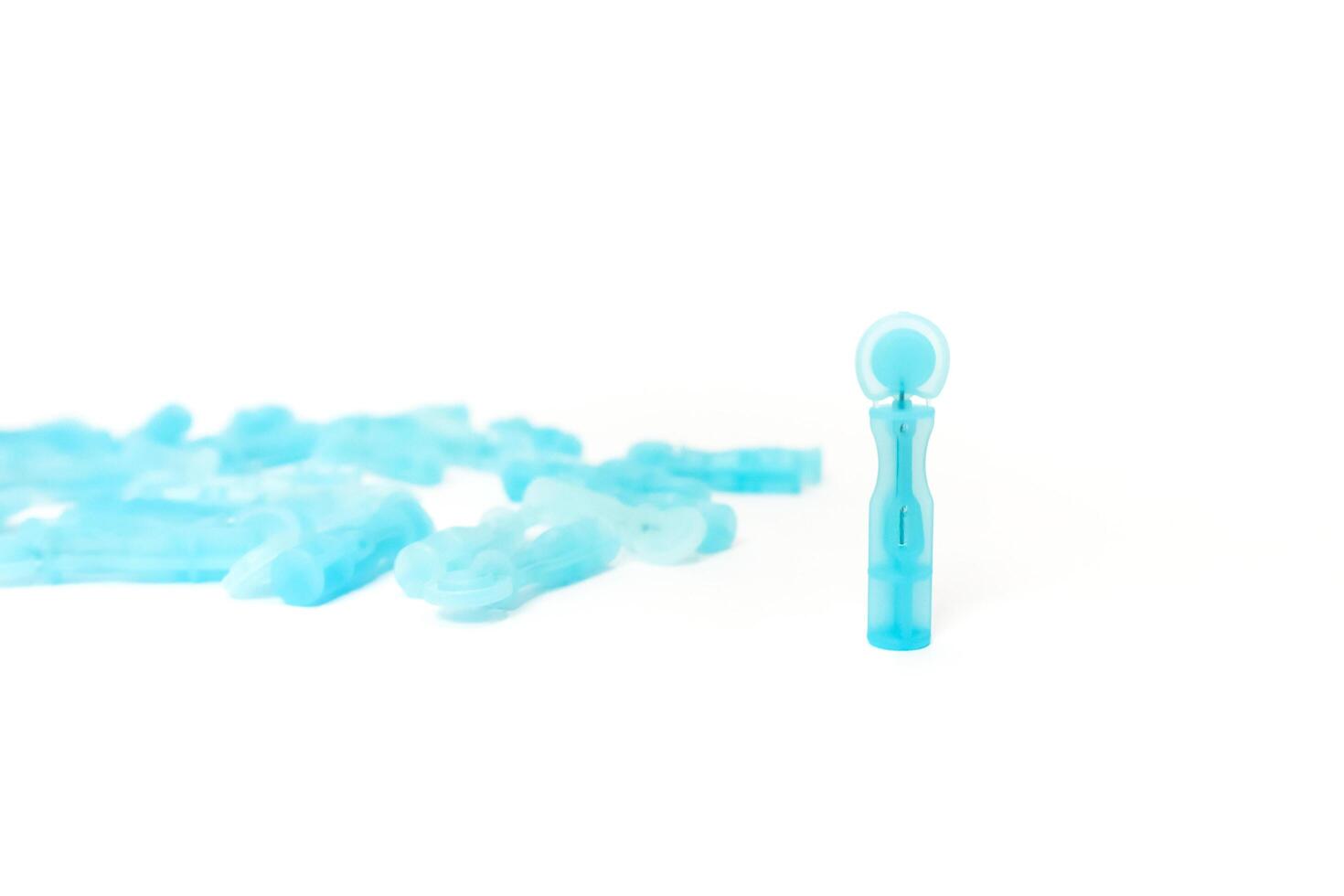 Close-up of sterile lancets for blood sugar testing on white background, used for diabetes health monitoring and medical diagnostic photo