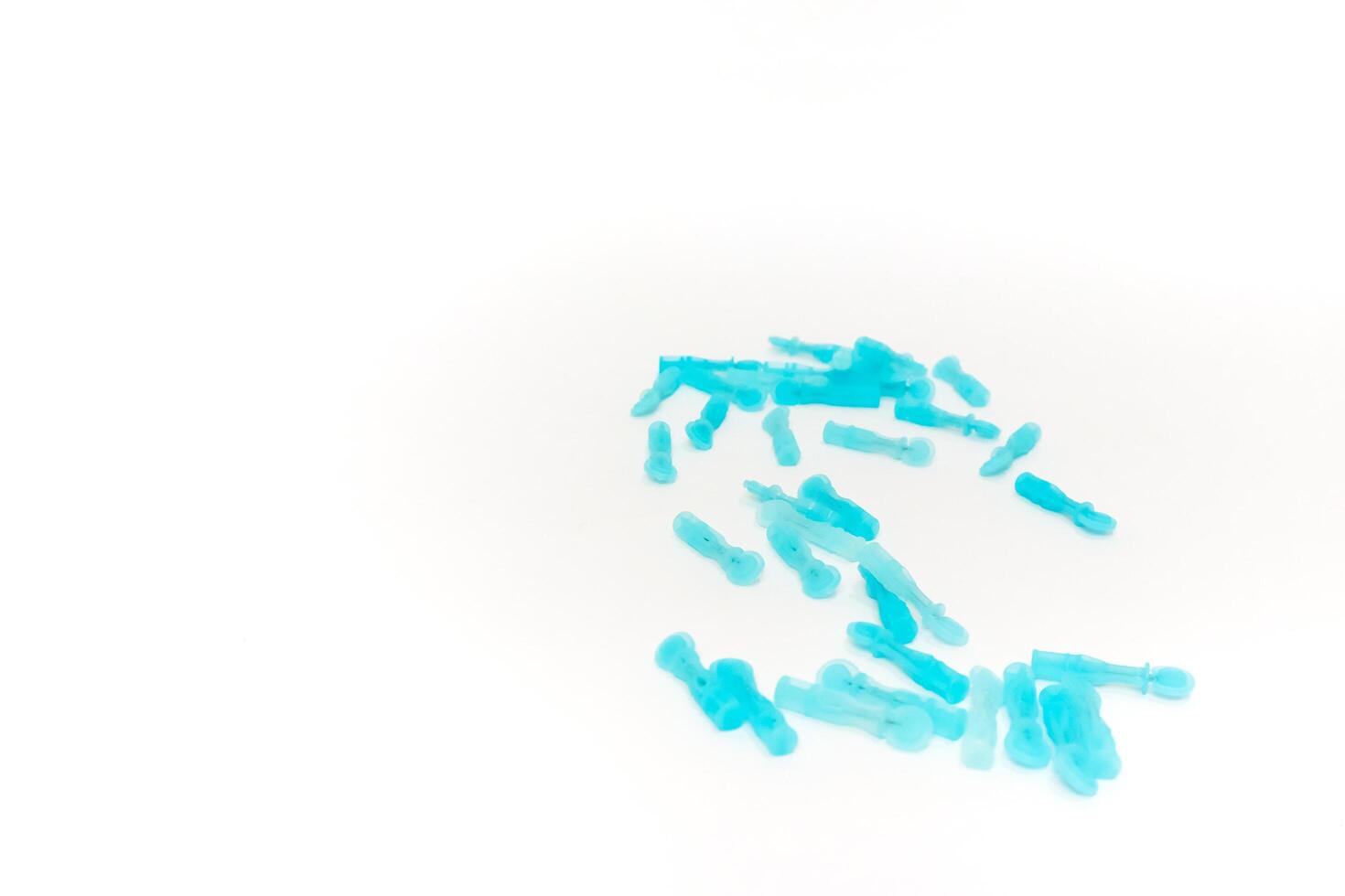 Close-up of blue medical lancets for blood sugar testing on white background depicting diabetes care and monitoring equipment photo