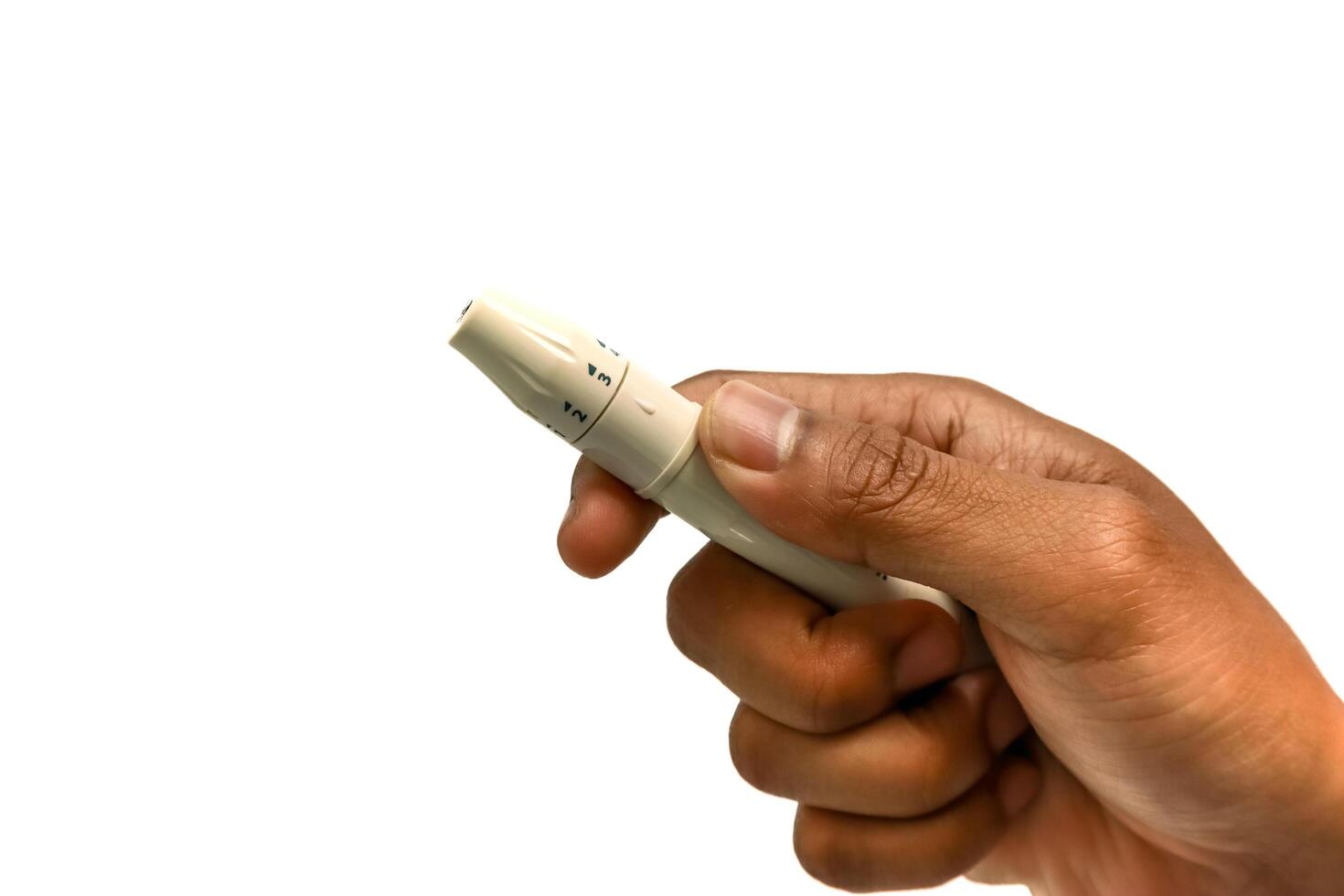 Close-up of hand holding lancing device for blood glucose testing, used for diabetes management photo
