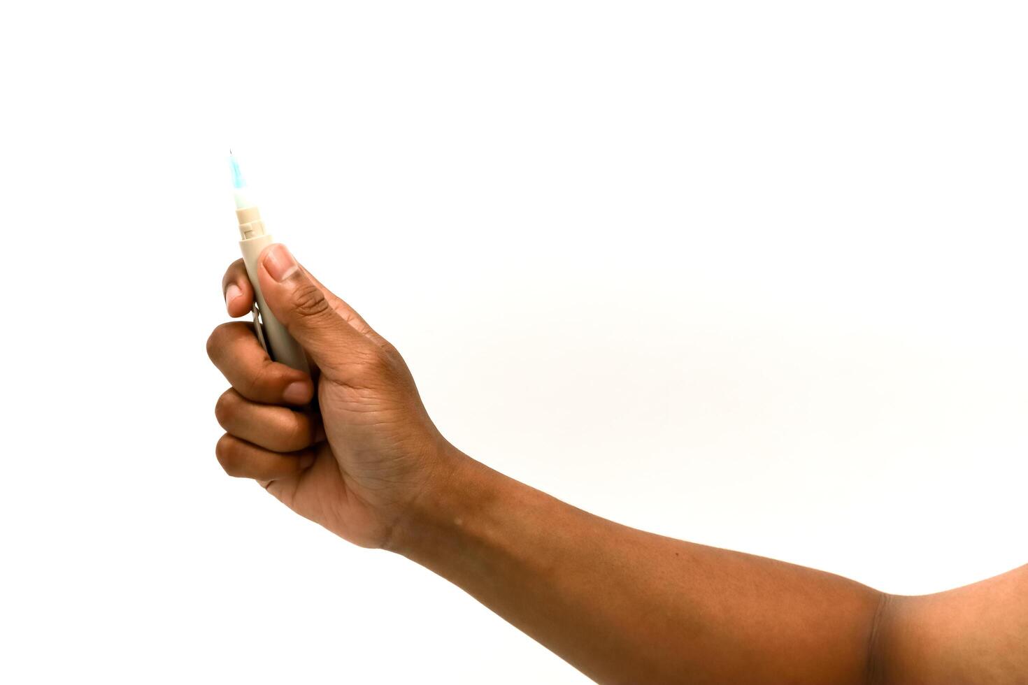 Close-up of hand holding lancet device for blood sugar testing on white background photo