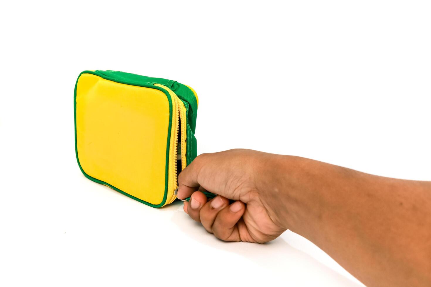 Hand opening a vibrant yellow and green cosmetic bag on a white background, studio shot photo