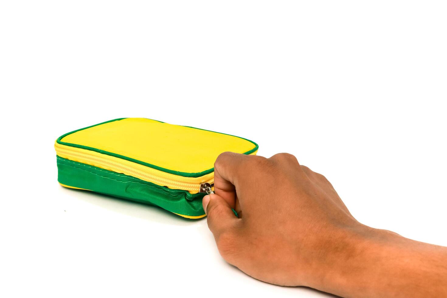 Opening a Yellow and Green Pencil Case with Zipper on a White Background photo