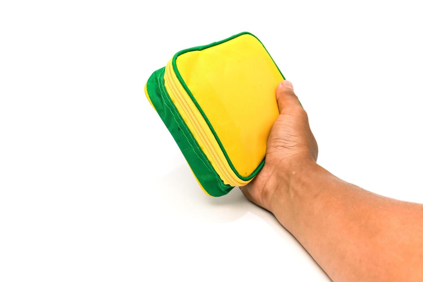 Hand Holding a Yellow and Green Cleaning Sponge on a White Background, Studio Shot photo