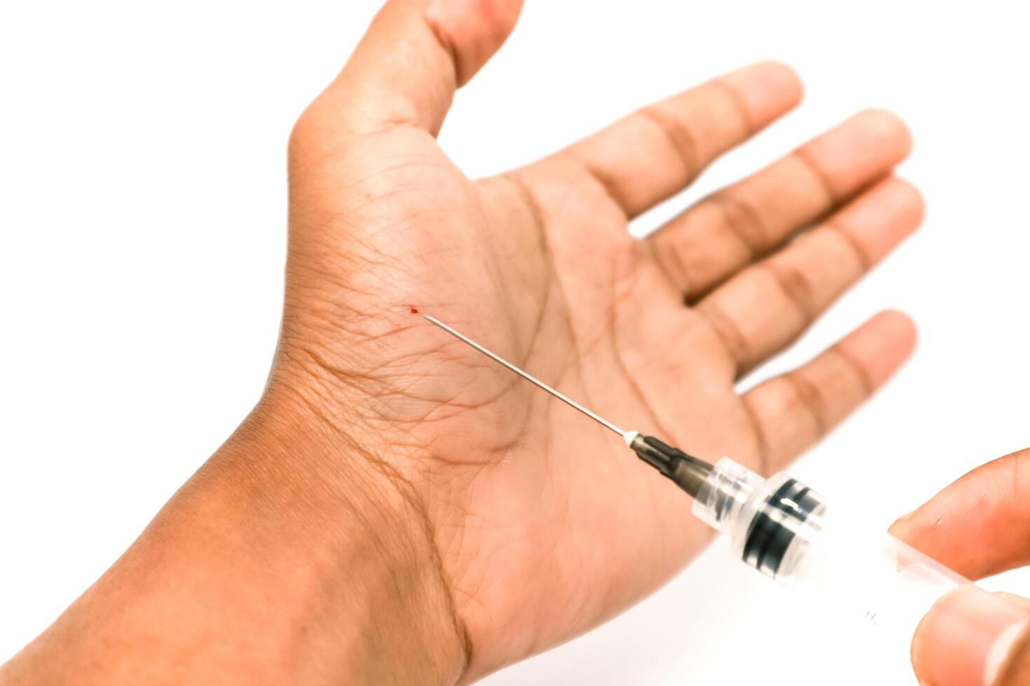 Close-up of needle injecting into hand palm, representing vaccination, blood testing, or medical procedure in a clinical setting photo