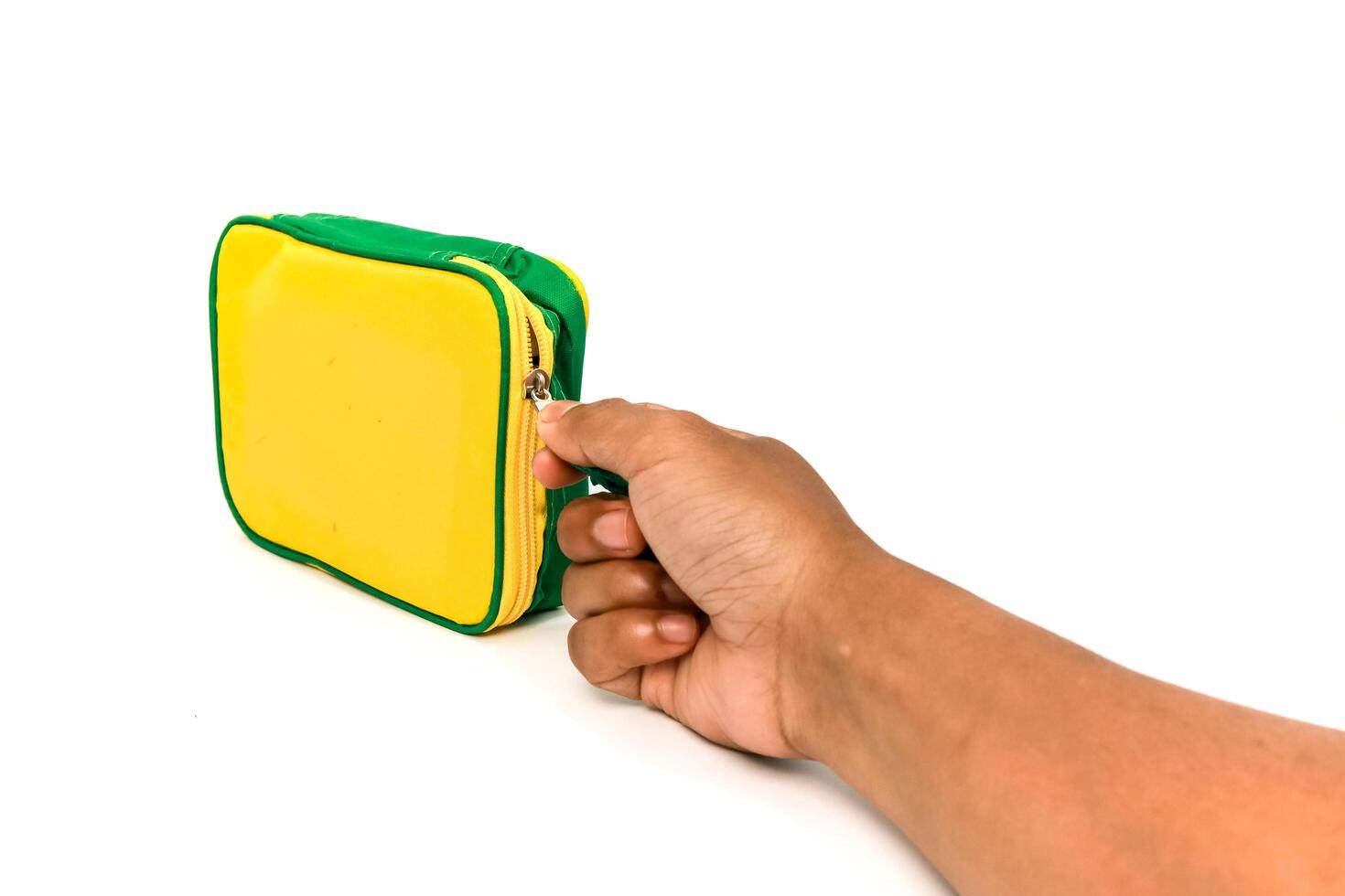 Hand opening yellow and green zipped cosmetic bag on a white background photo