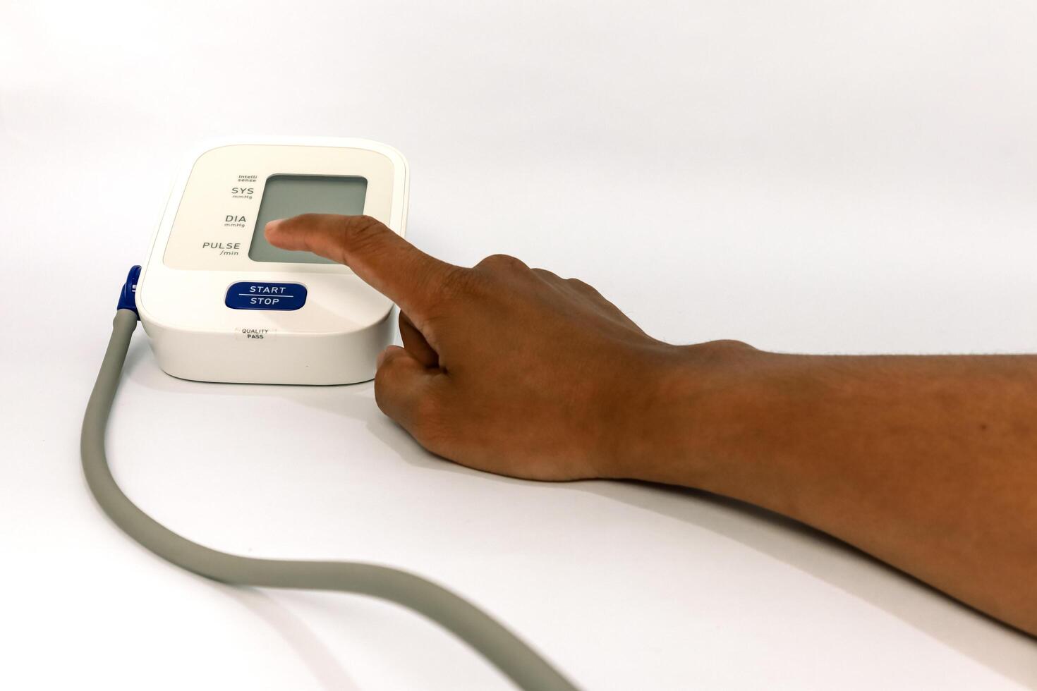 Close-up of a person using a digital blood pressure monitor on a white background photo