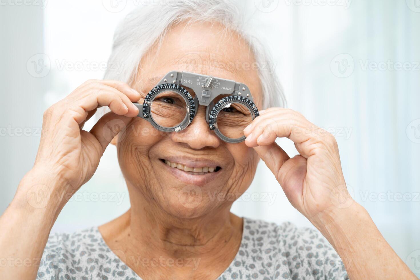 senior wearing ophthalmic vision eye test and using optical trial frame. photo