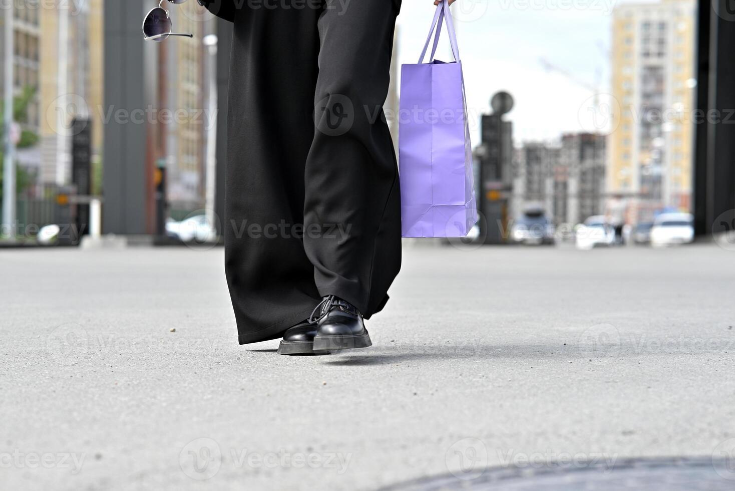 Woman purple shopping bag on a city street. photo