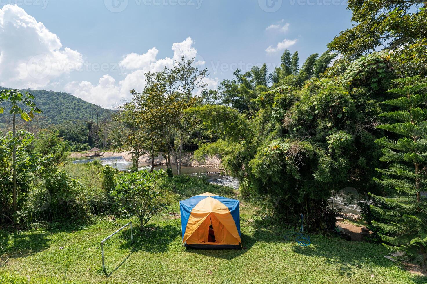 Tent camping on lawn with blue sky in tropical rainforest at countryside photo
