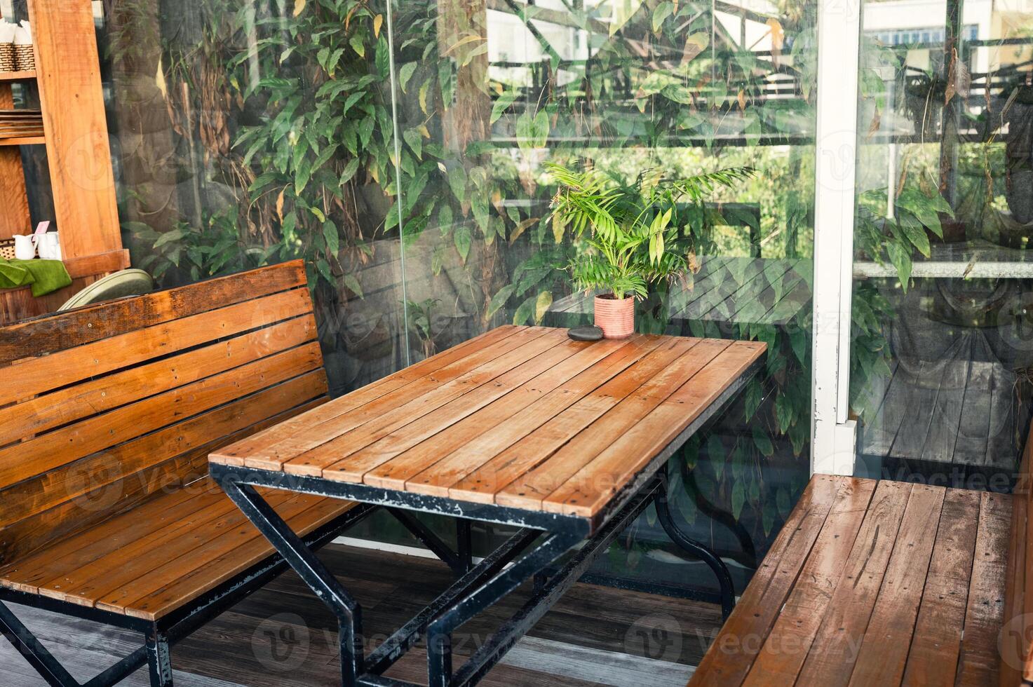 Wooden dining table and bench with green plant photo