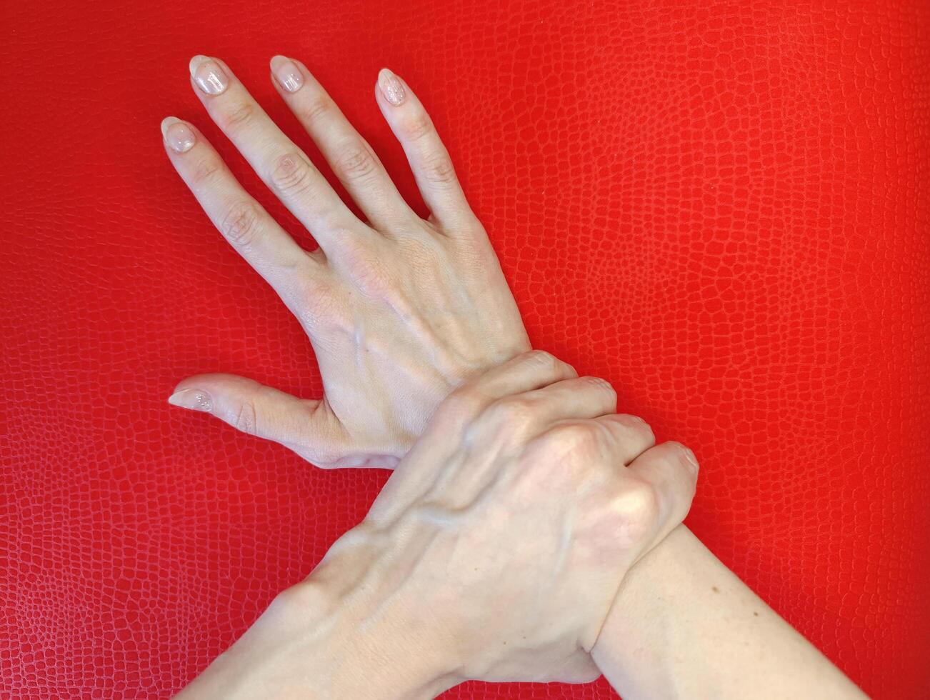 Hand gesture demonstrating support and connection on a vibrant red background photo