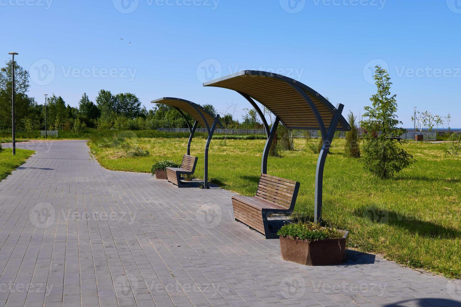 A modern park seating area that invites relaxation and enjoyment under clear blue skies photo