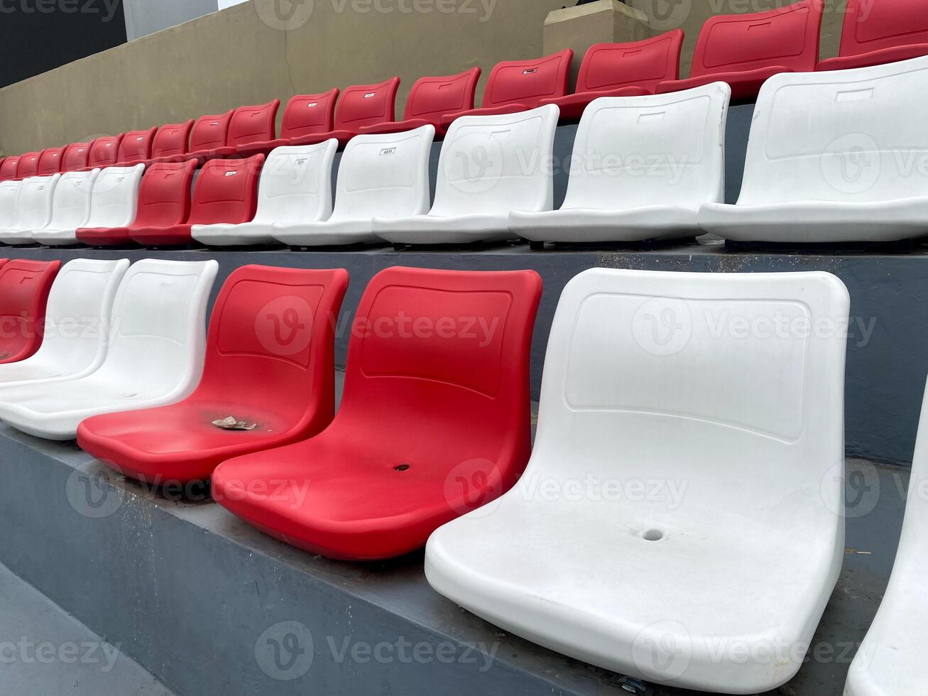 Empty Red and White Stadium Seats A Glimpse into a Quiet Stadium photo
