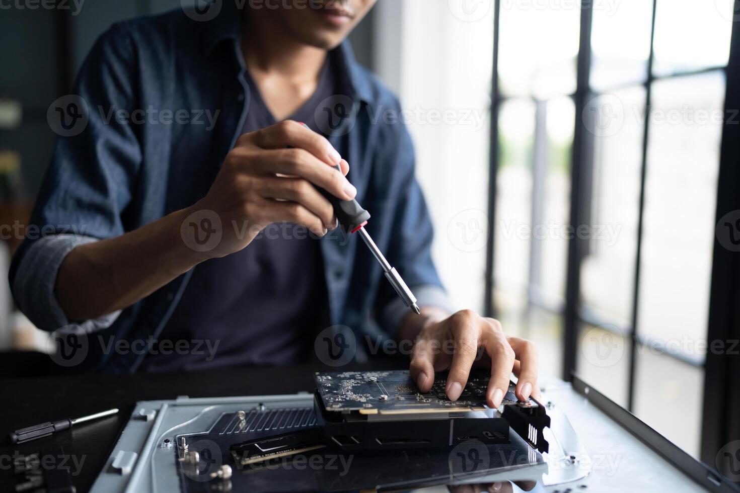 Engineer installing Hardware. man is working on a computer with a screwdriver photo