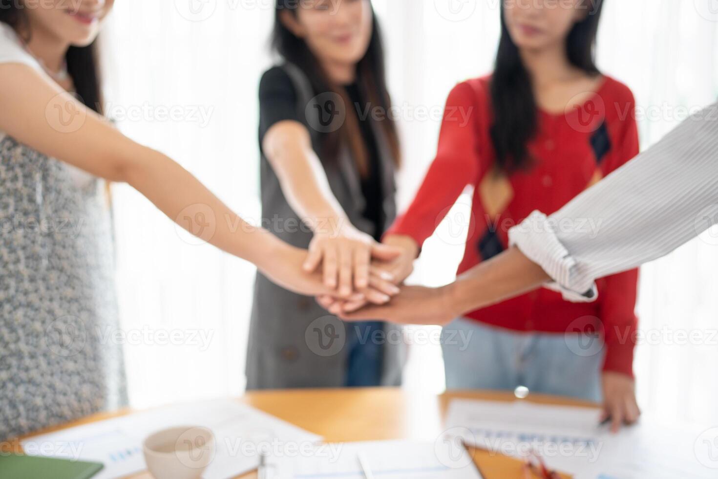four people holding hands around a table. photo