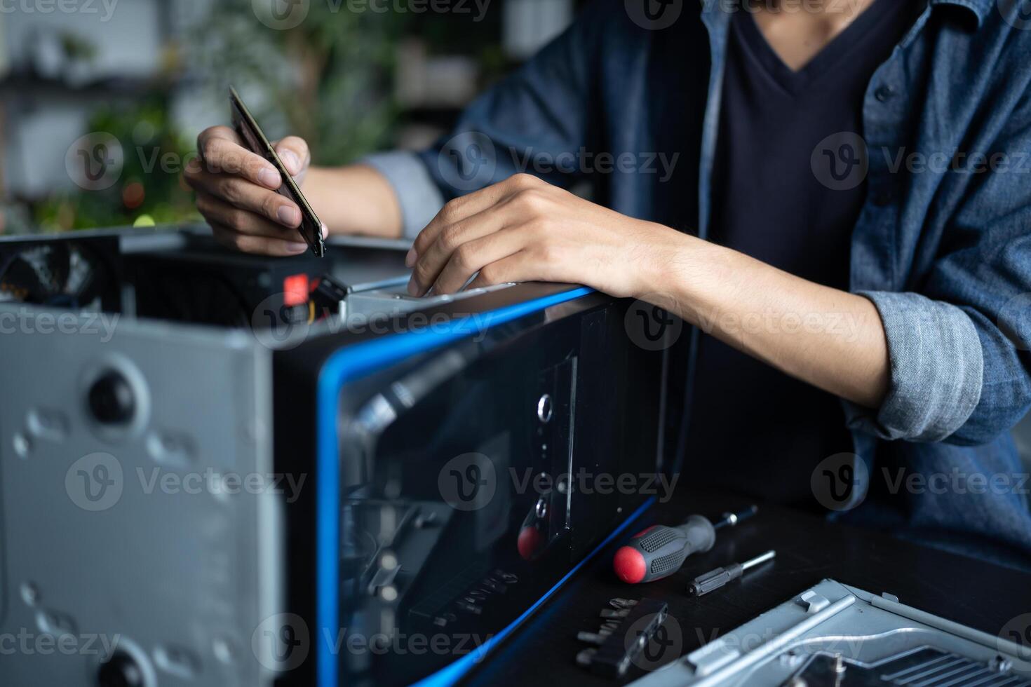 a Engineer man is working on a computer with a screwdriver photo