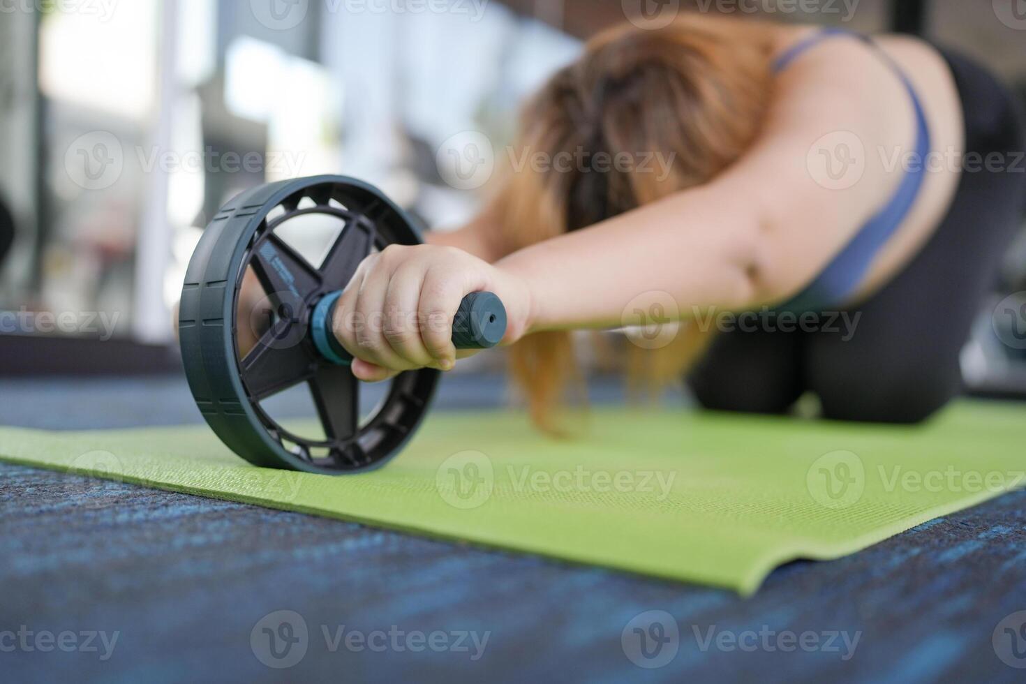 a Overweight woman is doing a push up on a green mat photo