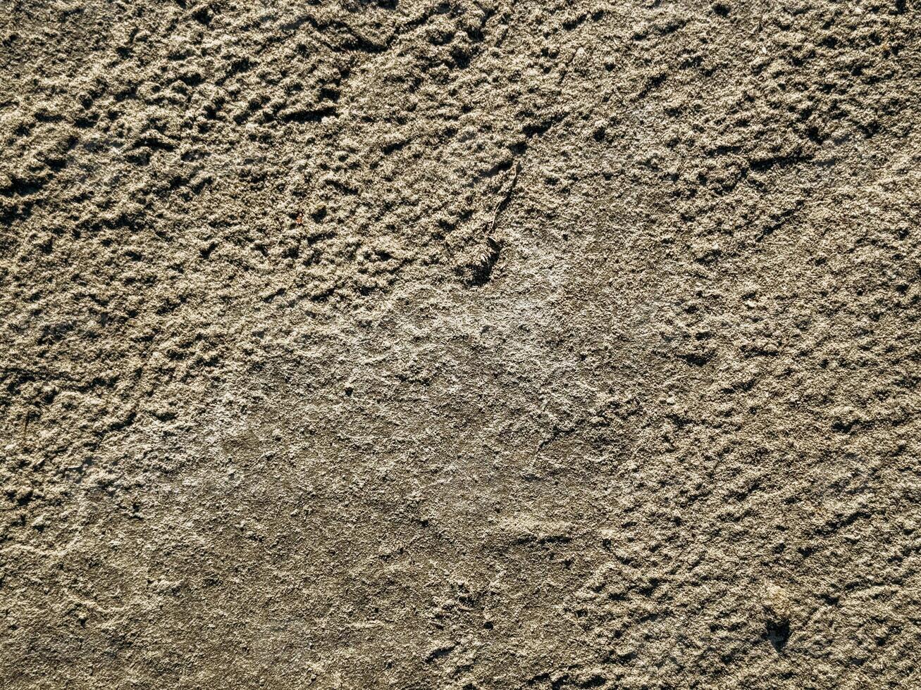 Textured Surface of Rough Concrete or Stone natural sand cliff texture with rough surface patterns and organic earthy tones perfect for eco backgrounds and design overlays photo