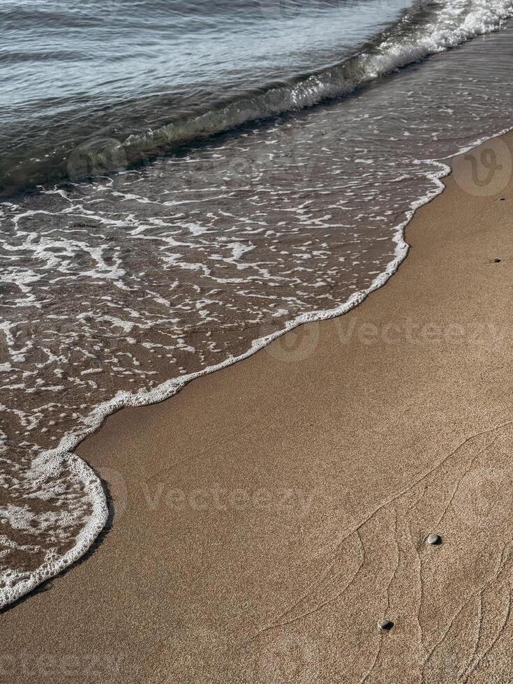 Golden sand surface with deep human footprints in warm sunlight showing beach texture and natural pattern photo