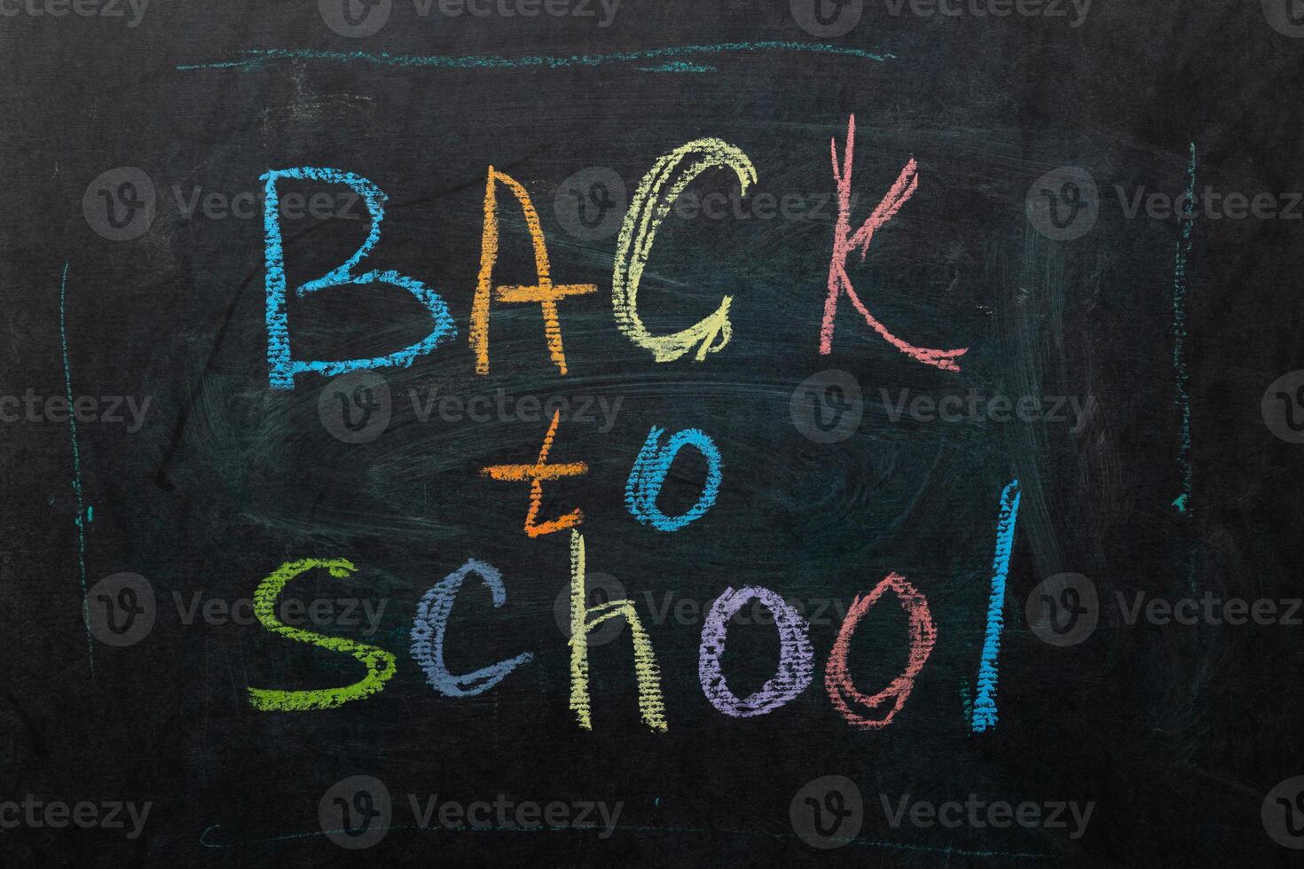Brightly Colored Chalk Lettering Announces Back to School on a Black Chalkboard photo