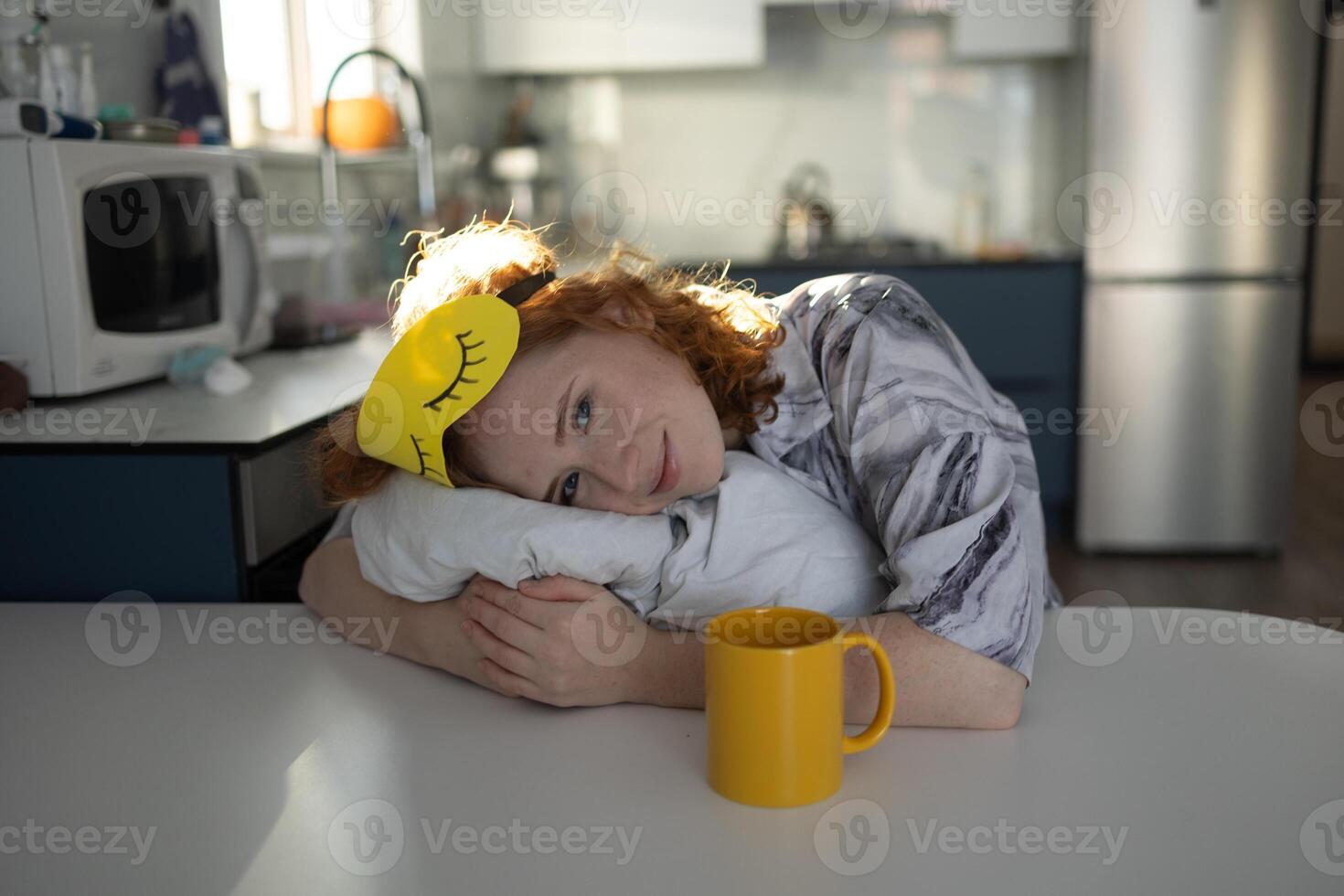 Joyful morning of a young girl in a sleep mask with invigorating coffee photo