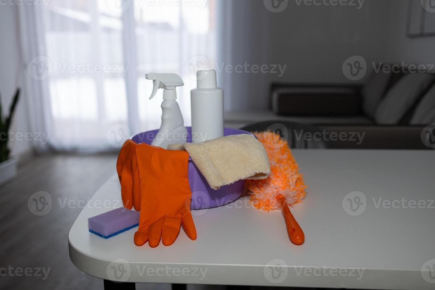 There is a table in the living room that has various cleaning supplies on it photo