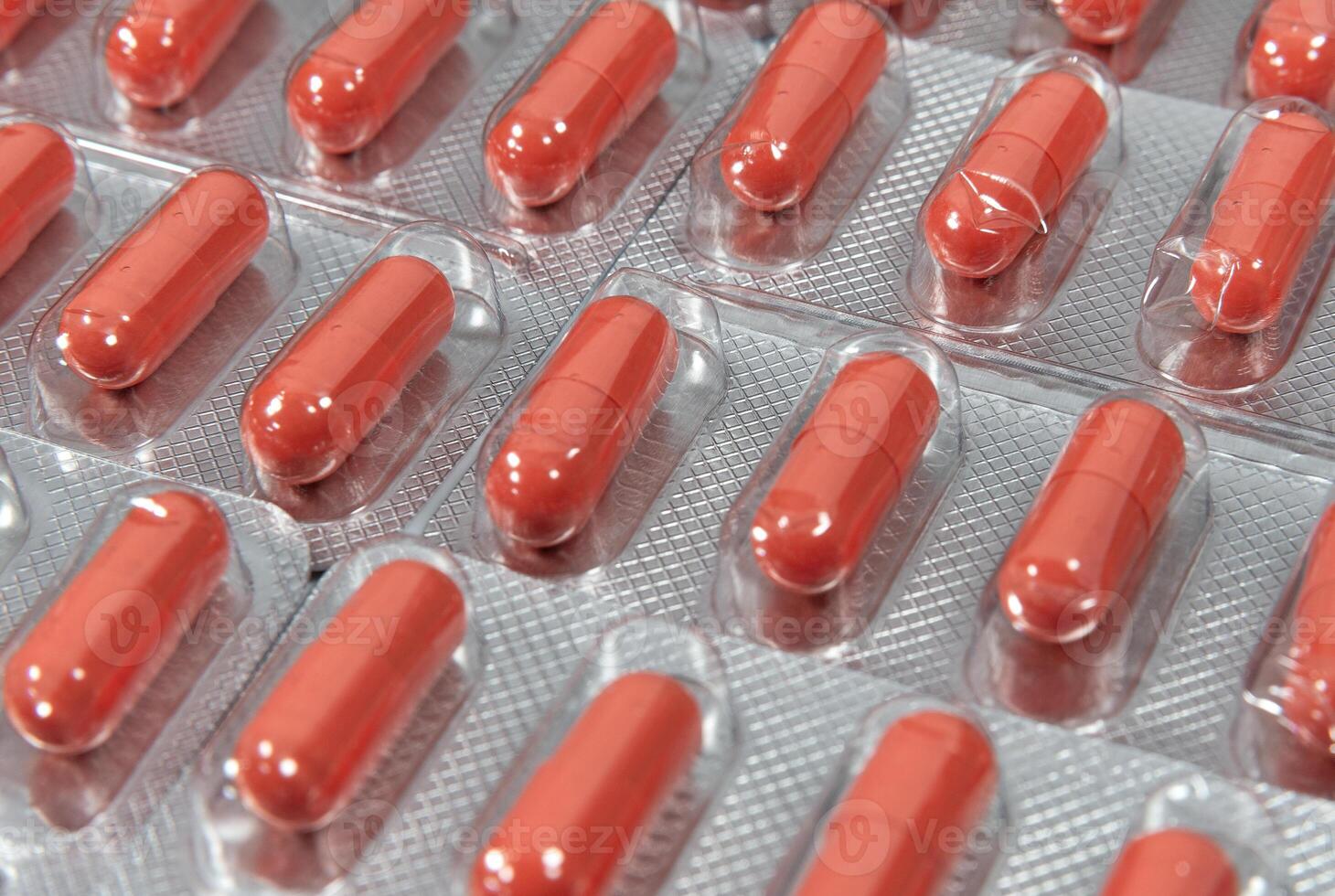 Red capsules in silver blister pack photo