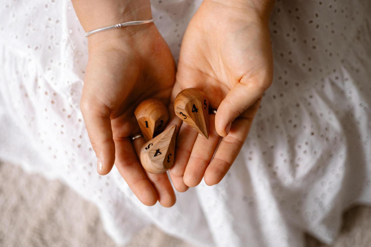 wooden dice with numbers in the hands of a girl photo
