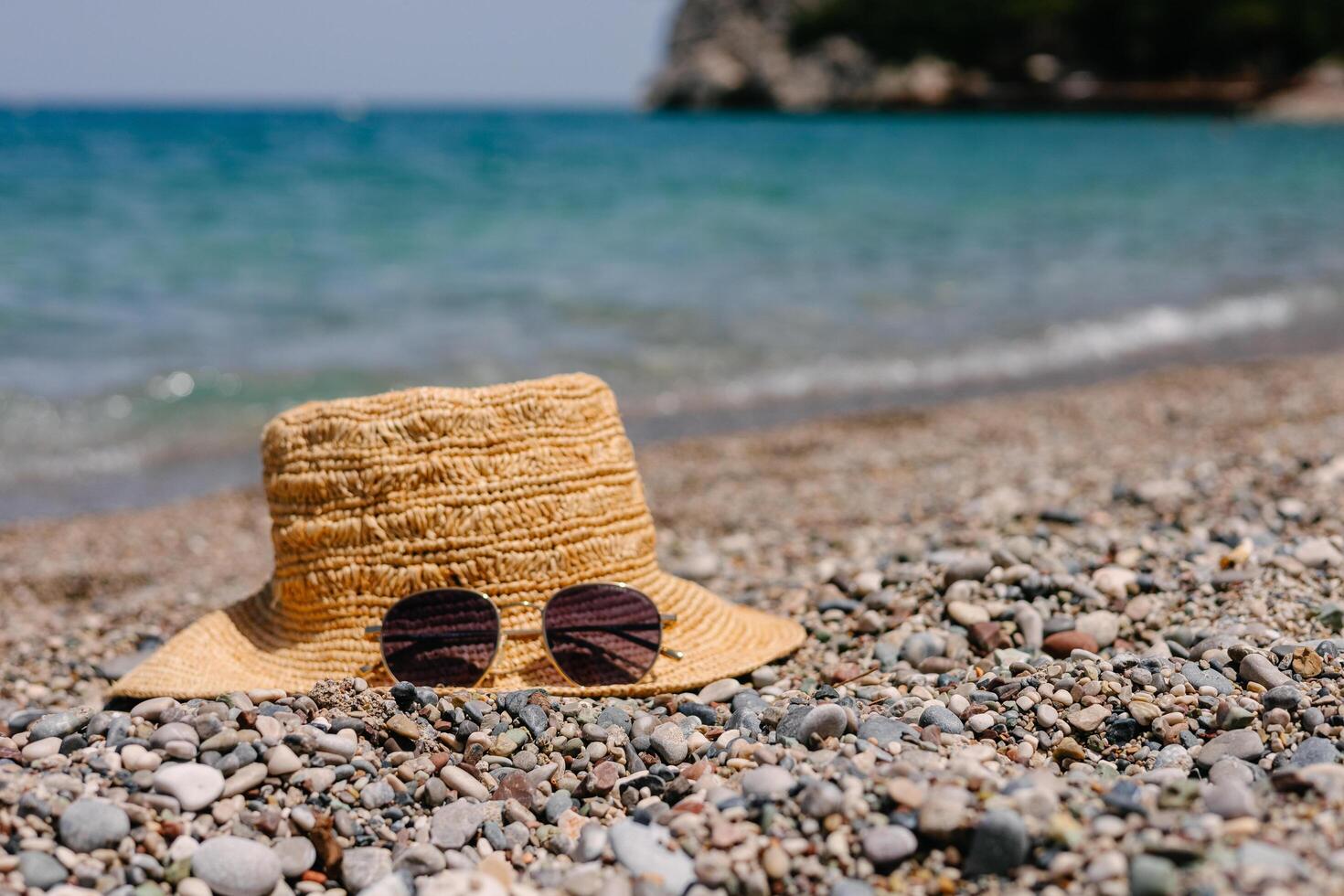 Straw hat and sunglasses on seashore photo