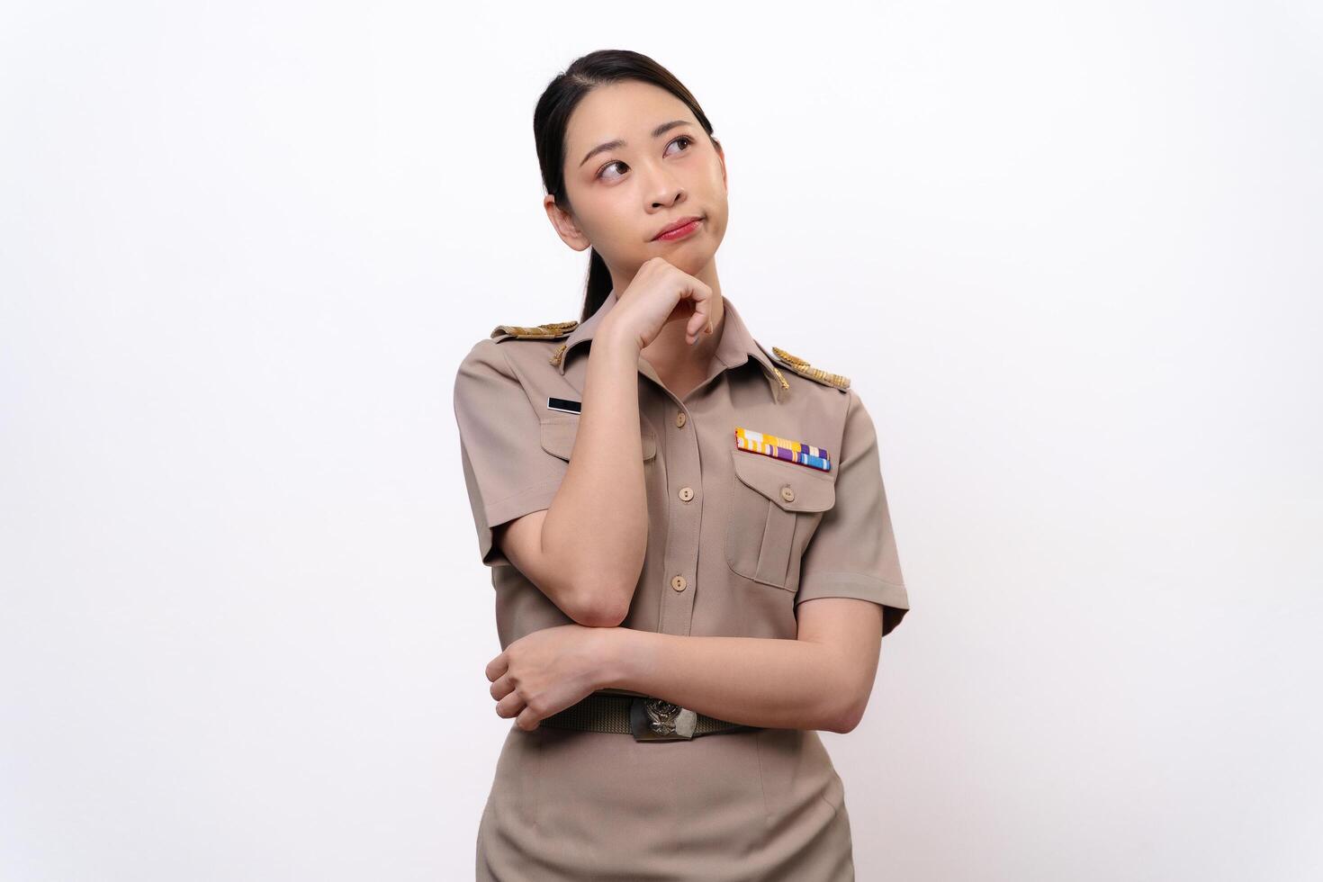 A curious woman in Thai asian teacher uniform is looking to the side. she is thinking something photo
