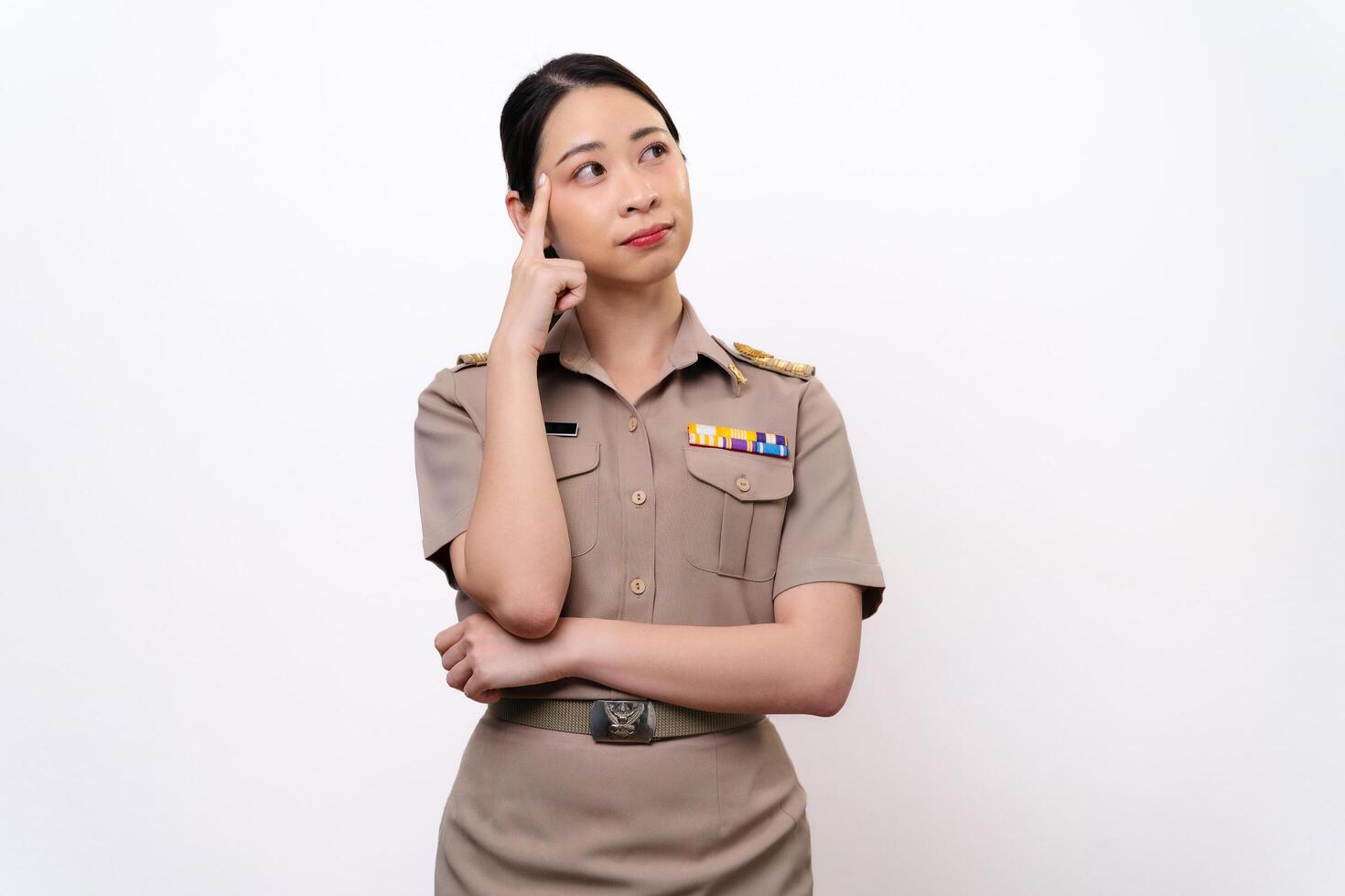 Curious woman in a Thai asian teacher uniform is looking to the side. she is thinking something photo