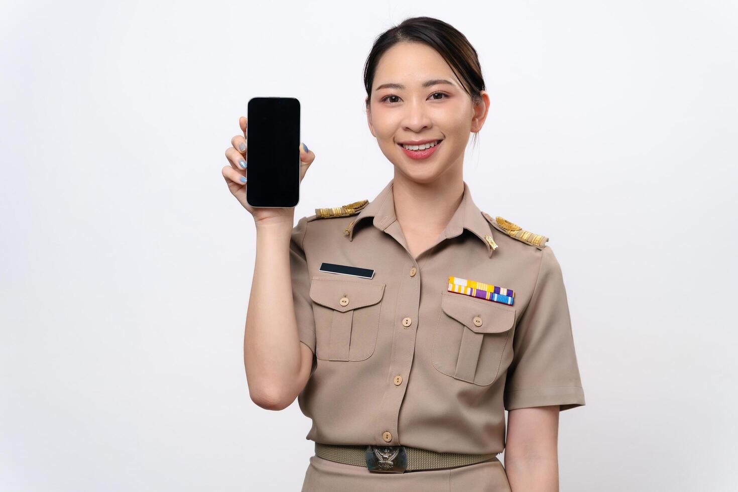 A beautiful Asian Teacher in the uniform shows a blank screen of mobile phone. photo