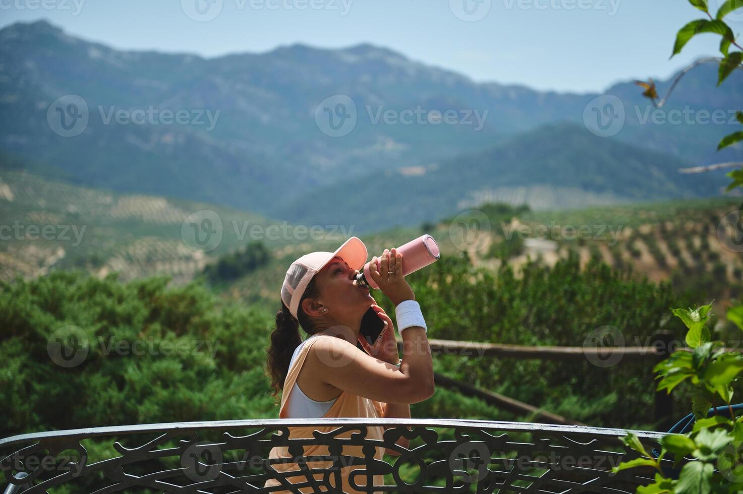 Active Woman Hydrating Outdoors Amid Scenic Mountain Views photo