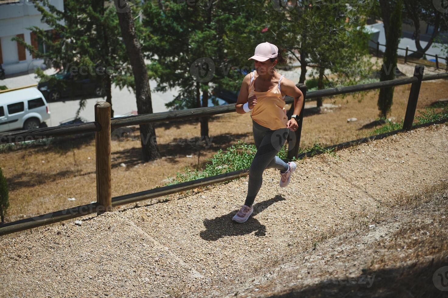 Woman Jogging Uphill on a Sunny Day in an Outdoor Park Setting photo