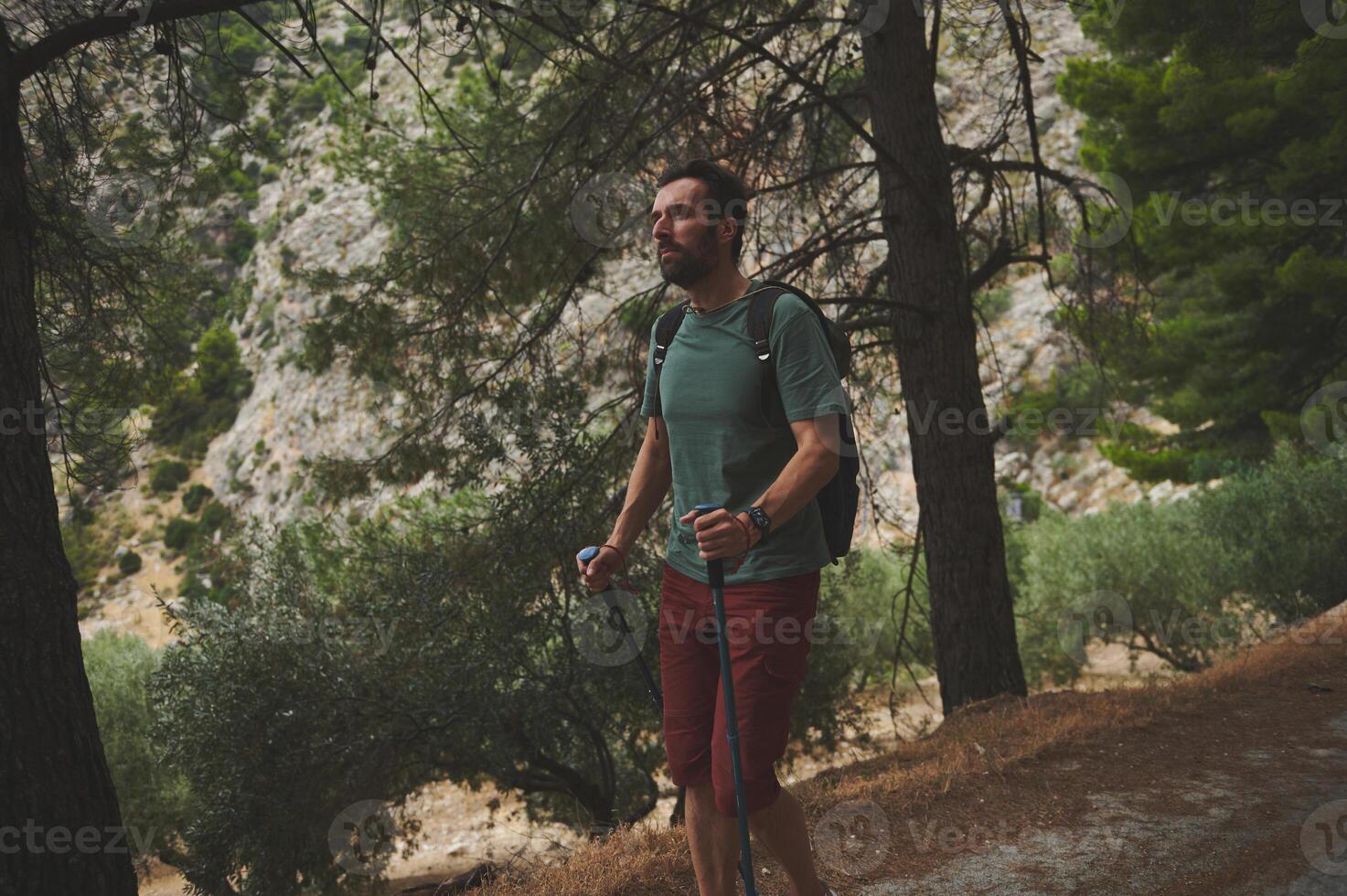 Male Hiker Enjoying Nature While Walking Through a Scenic Mountain Trail photo